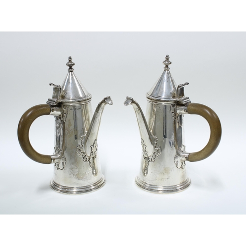 82 - Pair of George V silver café au lait pots, with domed lids and wooden handles, the spouts with hinge... 