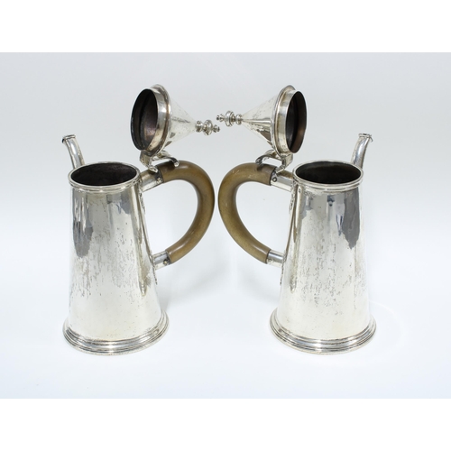 82 - Pair of George V silver café au lait pots, with domed lids and wooden handles, the spouts with hinge... 