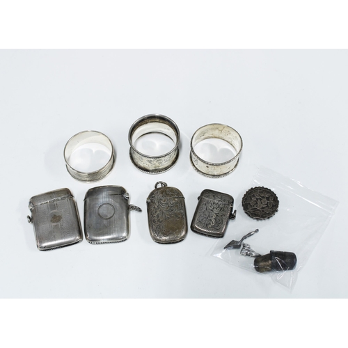 97 - Four silver vesta case, three silver napkin rings, two silver thimbles and a silver brooch (damaged)... 