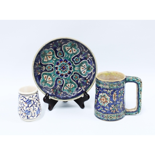 108 - A group of Iznik style pottery to include a plate, tankard and small mug (3) 19cm.