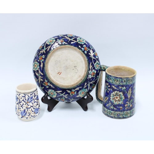 108 - A group of Iznik style pottery to include a plate, tankard and small mug (3) 19cm.