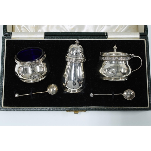 12 - George V silver five piece condiment set, boxed (with one glass liners missing) and a silver three p... 