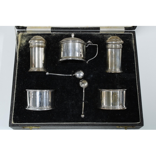 12 - George V silver five piece condiment set, boxed (with one glass liners missing) and a silver three p... 