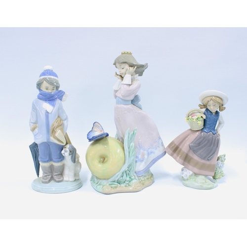 134 - Three Lladro figures to include a girl  in front of an apple and butterfly, (3) 23cm.