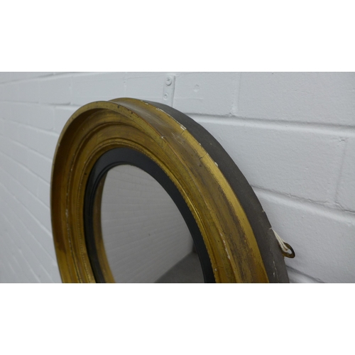 229 - Circular gilt framed wall mirror with an ebonised slip. 47cm.