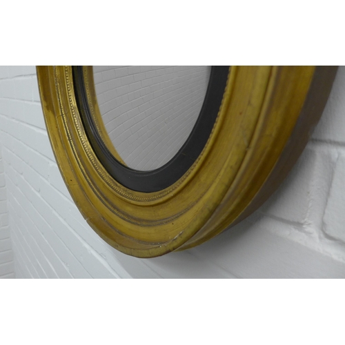 229 - Circular gilt framed wall mirror with an ebonised slip. 47cm.