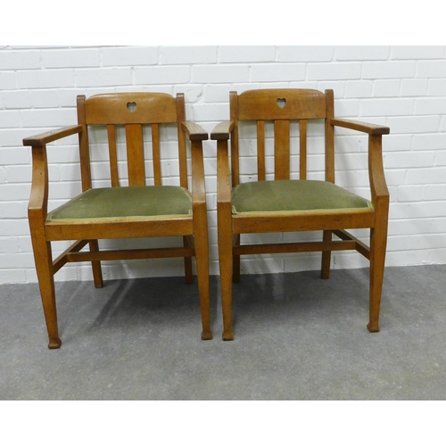 252 - A pair of Arts & Crafts oak open armchairs  in the manner of Liberty & Co, with pierced hearts to th... 