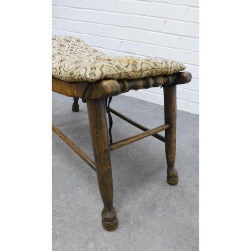 253 - An Arts & Crafts elm stool with a concave woven rush seat, 39 x 76 x 33cm.