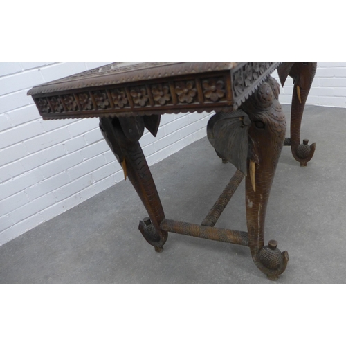 280 - Early 20th century Indian carved hardwood table on elephant head supports,  73 x 122 x 58cm. (a/f)