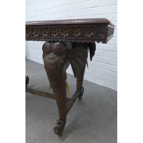 280 - Early 20th century Indian carved hardwood table on elephant head supports,  73 x 122 x 58cm. (a/f)