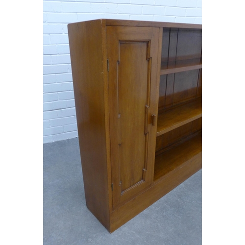 297 - An open bookcase, central shelves flanked by cupboard doors. 93 x 166 x 23cm.