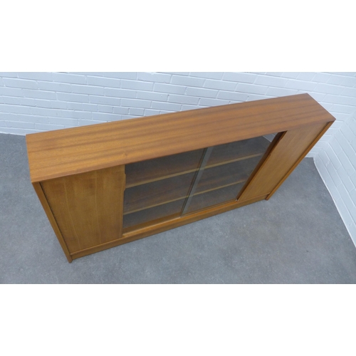 299 - Herbert E.Gibbs teak bookcase with glass sliding doors. 85 x 153 x 25cm.