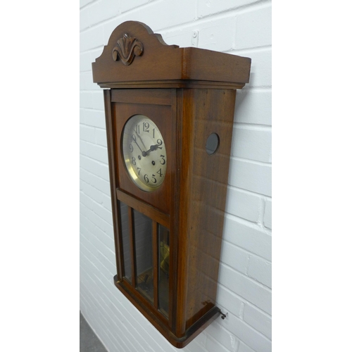 302 - Mahogany cased wall clock, silvered dial and arabic numerals, complete with pendulum . 74 x 33 x 18c... 