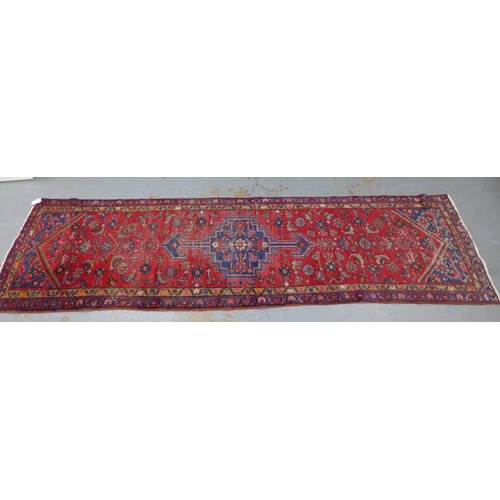 315 - North West Persian runner, red field with a pole medallion and flowerhead borders, 306 x 87cm