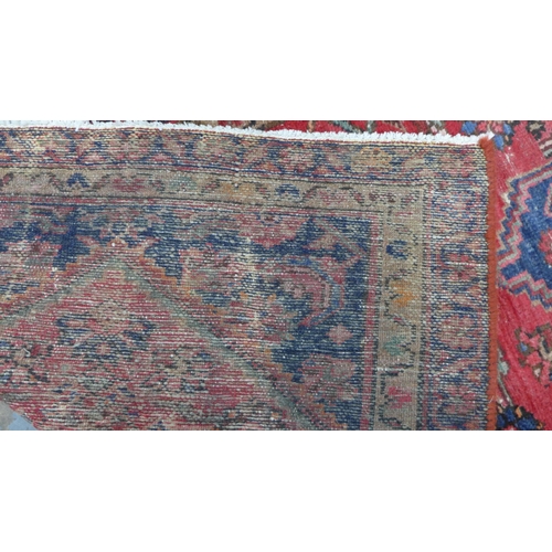 315 - North West Persian runner, red field with a pole medallion and flowerhead borders, 306 x 87cm