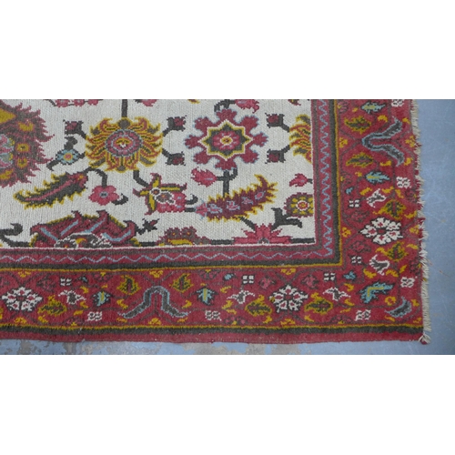 318 - Persian rug, ivory field with flowers and foliage within a red border, 265 x 185cm