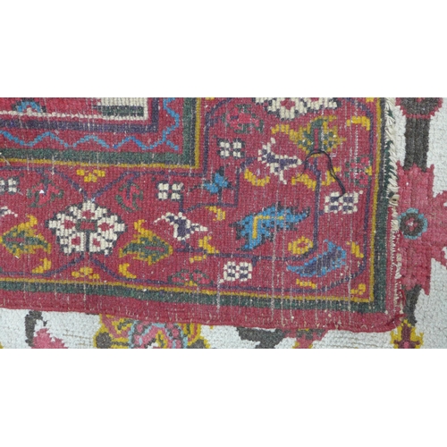 318 - Persian rug, ivory field with flowers and foliage within a red border, 265 x 185cm