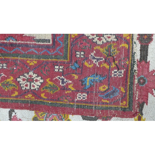 318 - Persian rug, ivory field with flowers and foliage within a red border, 265 x 185cm