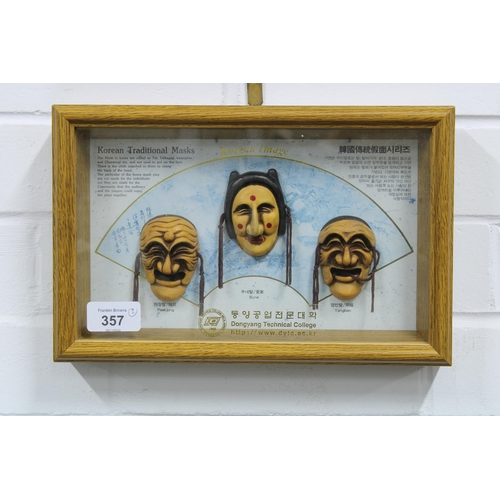 357 - Korean Traditional Masks in a small showcase, 29 x 19cm,  frame and another with four painted face m... 