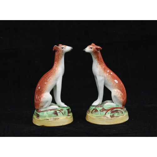 135 - Pair of 19th century Staffordshire hounds on circular bases, (2) 10cm.