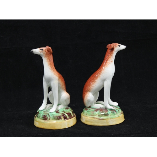 135 - Pair of 19th century Staffordshire hounds on circular bases, (2) 10cm.