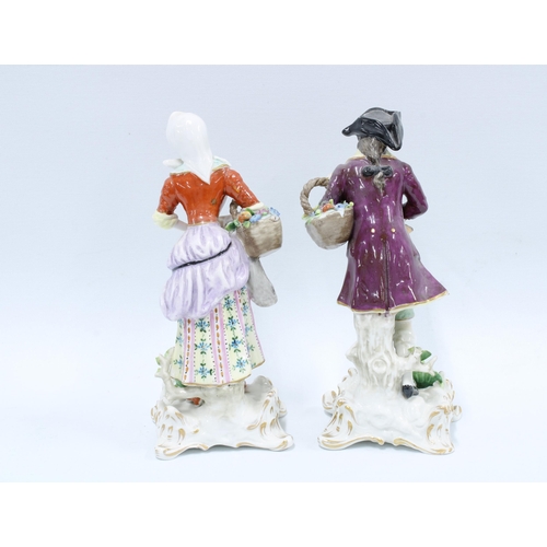 147 - A pair of Continental porcelain male and female figures, both carrying  a basket of flowers, the fem... 