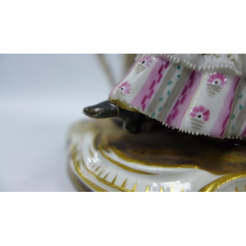 190 - 19th century porcelain figure of a woman sat in a high back chair beside a spinning wheel, blue cros... 