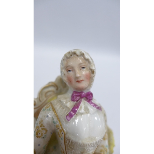 190 - 19th century porcelain figure of a woman sat in a high back chair beside a spinning wheel, blue cros... 