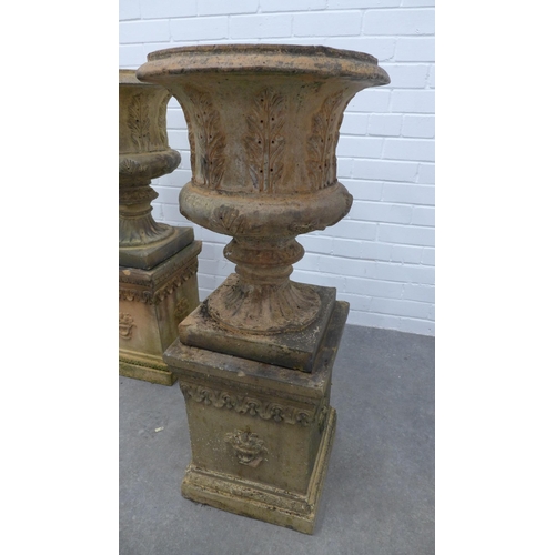 281 - Pair of fireclay garden urns, campana form with acanthus leaf detail, on rectangular plinths . 93 x ... 