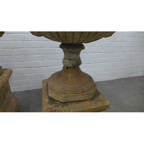 282 - Pair of garden urns, on stands. (one is A/F) 87 x 49cm. (2)