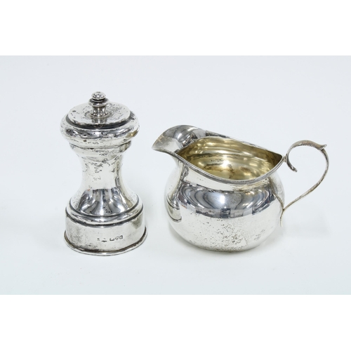 35 - George V silver cream jug, Birmingham 1911 and an Edwardian silver pepper grinder, Chester 1904 (2)