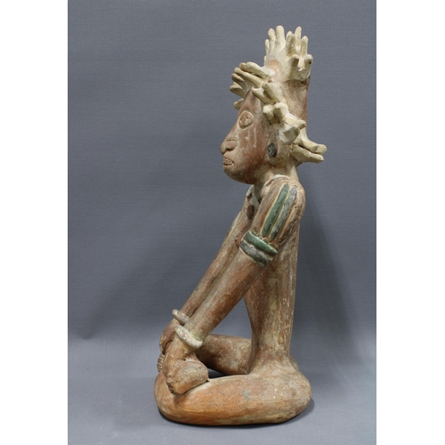 424 - South American clay pottery figure, modelled seated in cross leg pose, 39cm