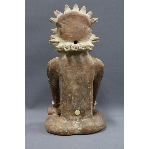 424 - South American clay pottery figure, modelled seated in cross leg pose, 39cm