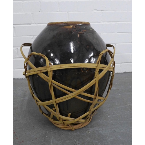 213 - Large Chinese brown glazed wine pot, in a basket. 41cm.