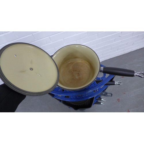 217 - A set of six  Le Creuset pots and pans, with a blue metal five tier Le Creuset stand