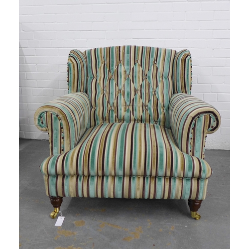 261 - Contemporary buttonback armchair with striped upholstery, on mahogany legs with brass caps and casto... 