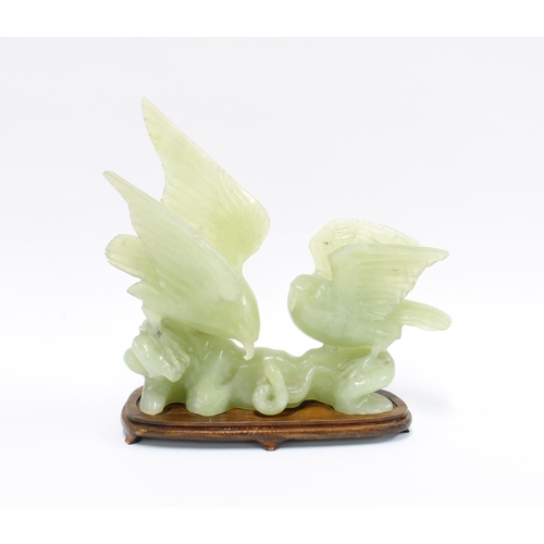 318 - Carved jadeite group of two birds, on a wooden stand, 21cm long, together with two jadeite cups (3)