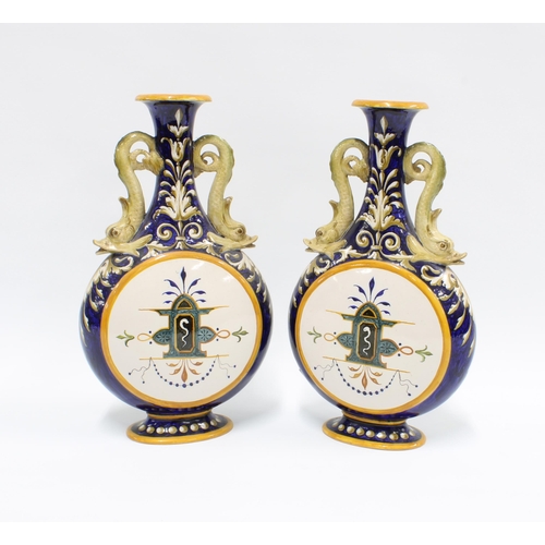 324 - A pair of Italian Ginori majolica vases, with dolphin handles and painted panels,  signed and number... 