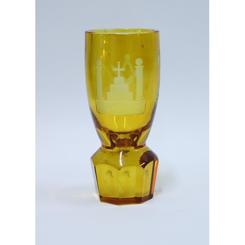 82 - Masonic firing glass, amber glass with etched square and compass on a circular facet cut base, 14cm