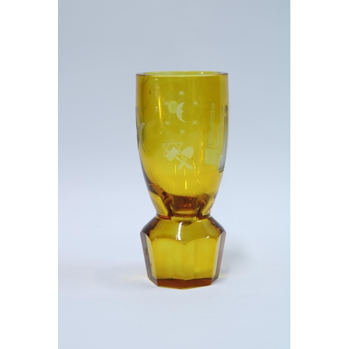 82 - Masonic firing glass, amber glass with etched square and compass on a circular facet cut base, 14cm