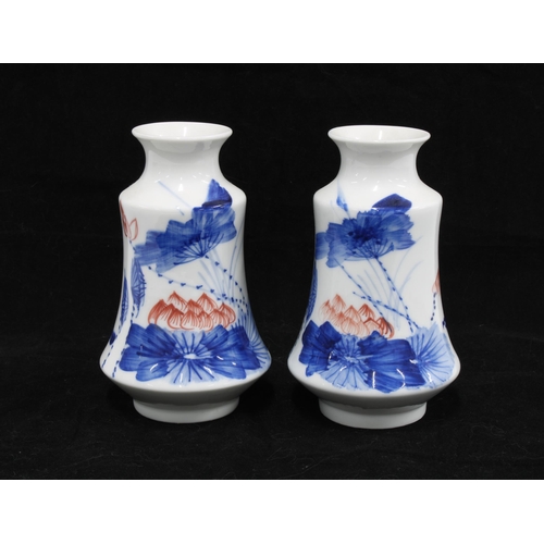 125 - A pair of Japanese porcelain vases , white glazed with blue an red flowers, 14cm (2)