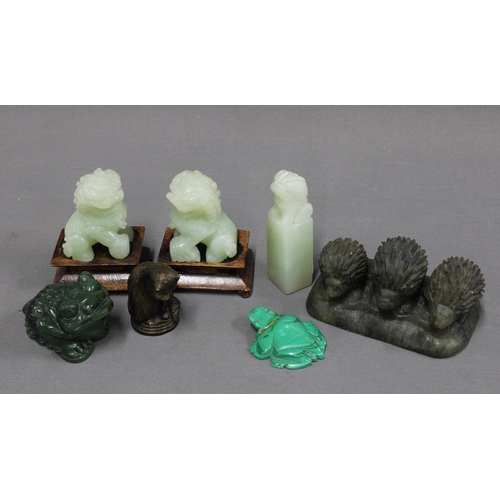 334 - A collection of jadeite carvings to include a pair of temple lions with wooden stands, 7cm, toad and... 