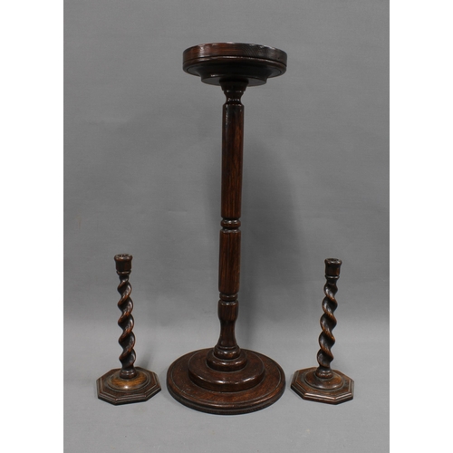 366 - A pair of Edwardian oak barley twist candlesticks and an oak stand with circular dished top, 61cm hi... 