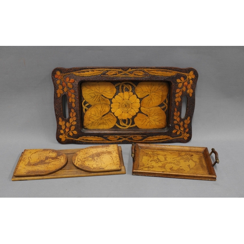 379 - Collection of pokerwork to include an Art Nouveau tray with lily pad leaves, 47cm long, a smaller tr... 