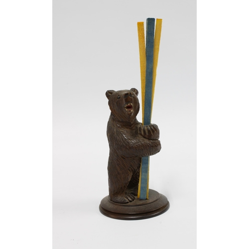 414 - Black Forest carved wood bear taper stick holder, modelled standing on a circular base, 12cm