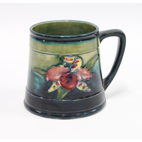 84 - Moorcroft Orchids pattern tankard with a blue and green ground, impressed facsimile signature, 10cm