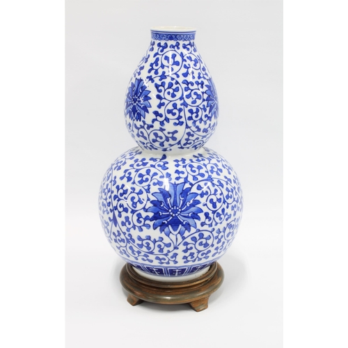 Chinese blue and white double gourd vase, attached to the hardwood base