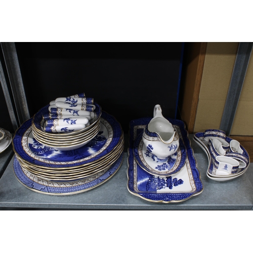 150 - Willow pattern blue and white dinner service and teaset together with a vase, candlesticks, etc tall... 