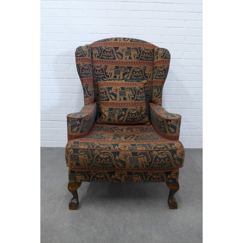 206 - Wingback armchair and matching footstool with elephant design upholstery on short cabriole legs with... 