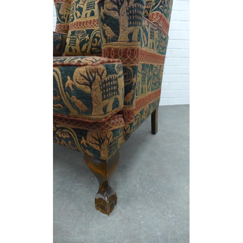 206 - Wingback armchair and matching footstool with elephant design upholstery on short cabriole legs with... 